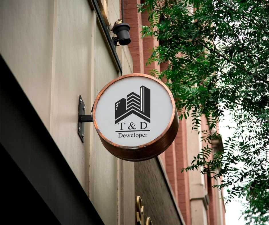 Szyld z logo dewelopera T&D Development na elewacji budynku