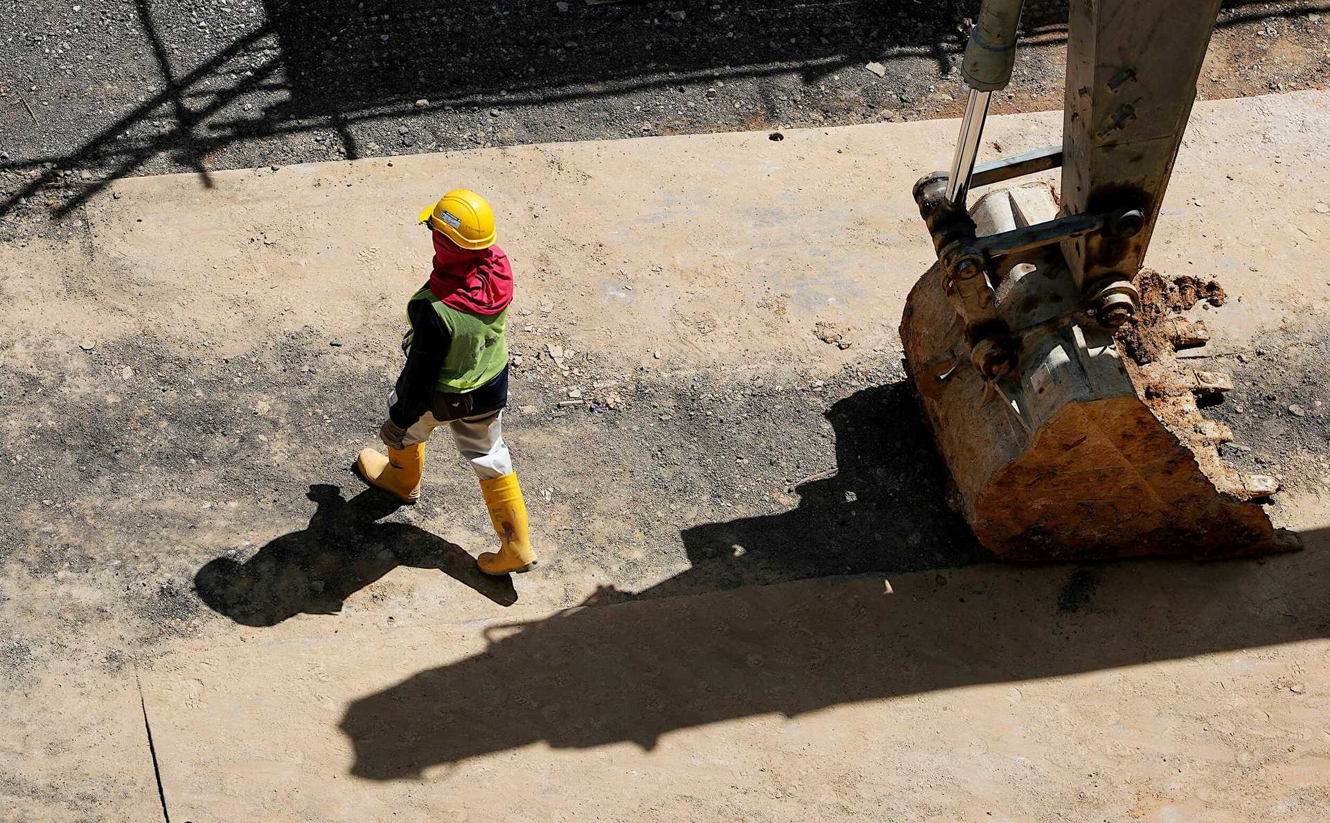 picture-construction-worker-wearing-a-vest-under-a-big-angle-around-the-excavator.jpg